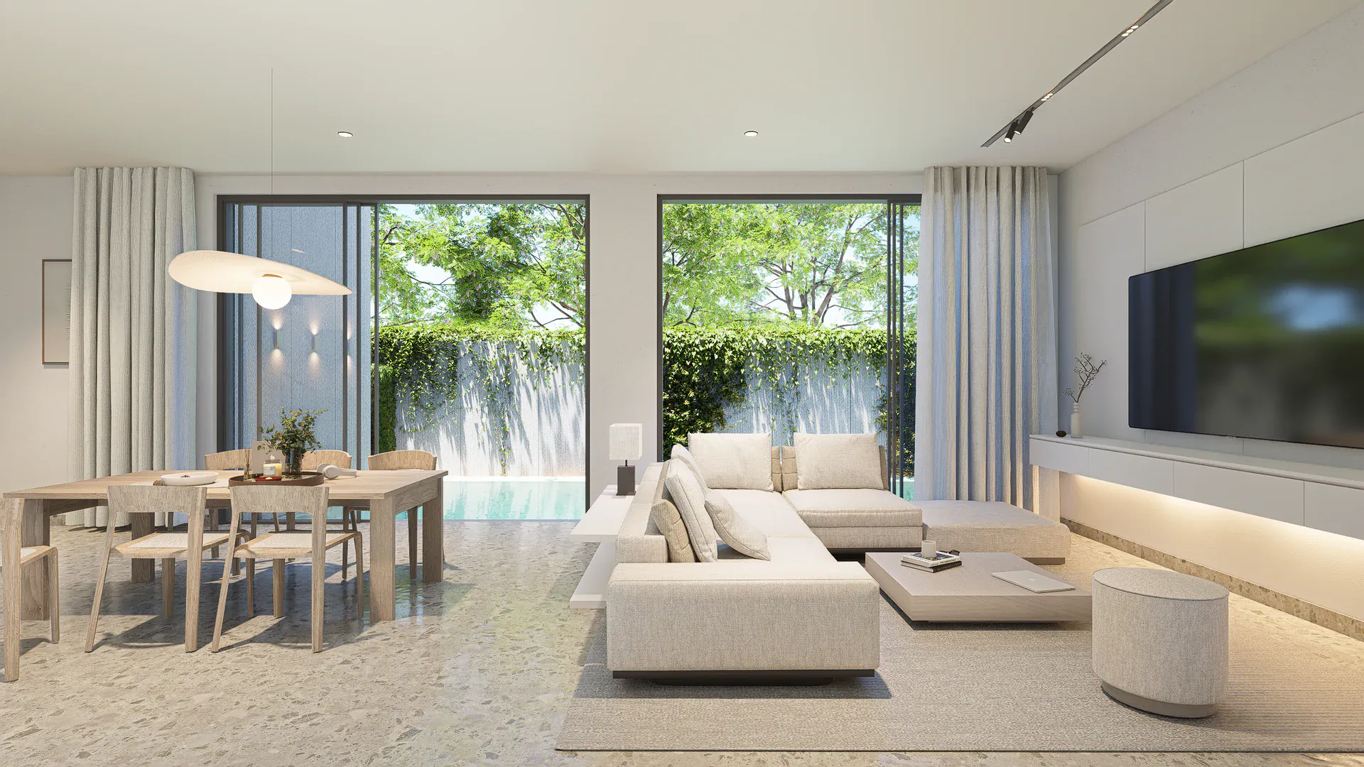 Shared living and dining space opening towards the protected pool edge and surrounding greenery.