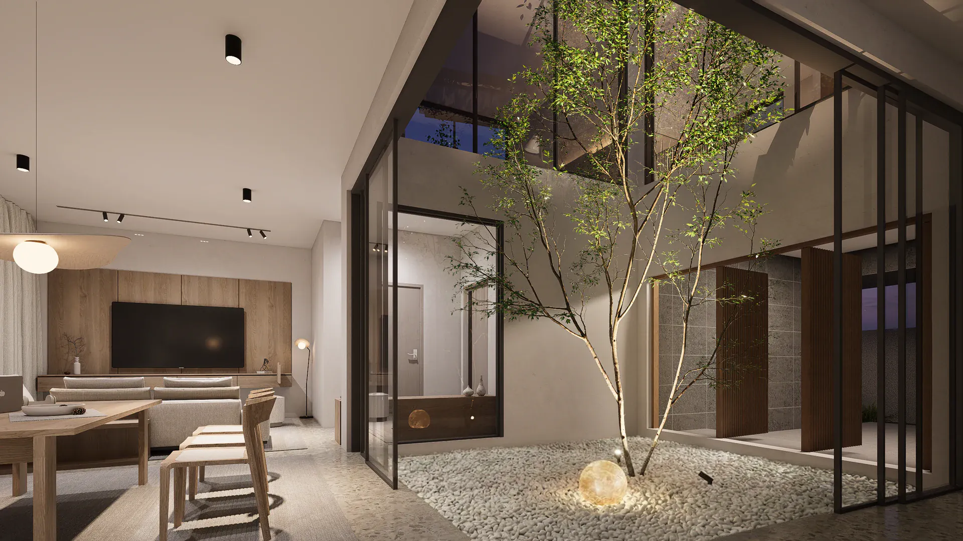 Evening view from the dining area across the illuminated courtyard towards the entrance and adjoining rooms.